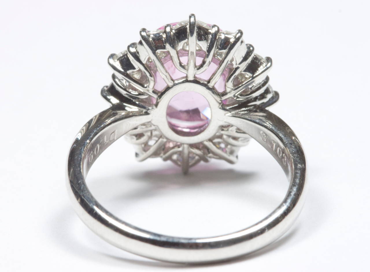 A lively and colorful 3.10 carat natural pink sapphire that has not been enhanced; is featured in this platinum flower motif halo ring that is designed with 1.09 carats of clean white, diamonds.

Ring size 6 and can be re-sized.