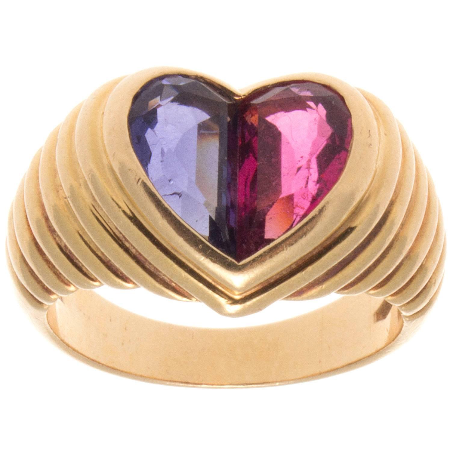 A striking color display from Bulgari. Opposites attract in this joining of a vibrant pink tourmaline and vivid purple amethyst set amid rolling contours of 18k gold. Signed Bulgari.

Ring size 5 3/4 and may be resized to fit.