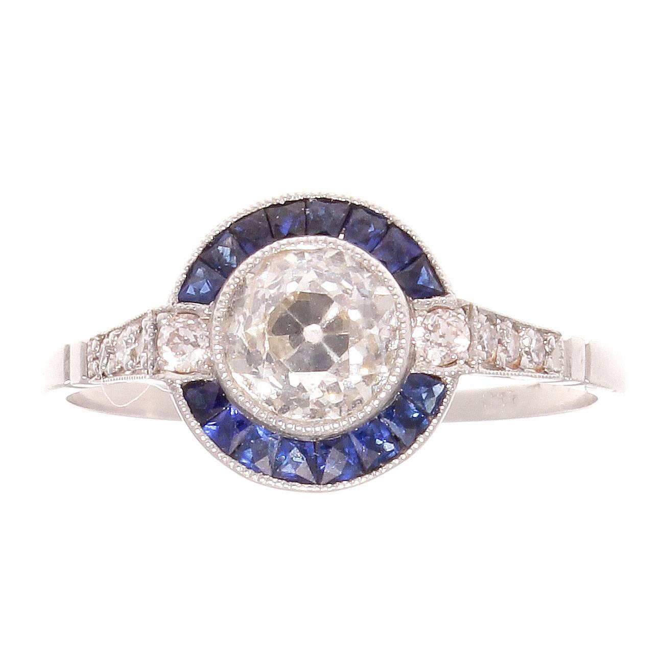 The 1930's is regarded as the golden age of jewelry and has influenced designers to recreate the jewelry from this remarkable time. Featuring an 0.86 carat diamond that is surrounded by a halo of navy blue sapphires. Hand crafted in platinum.
Ring