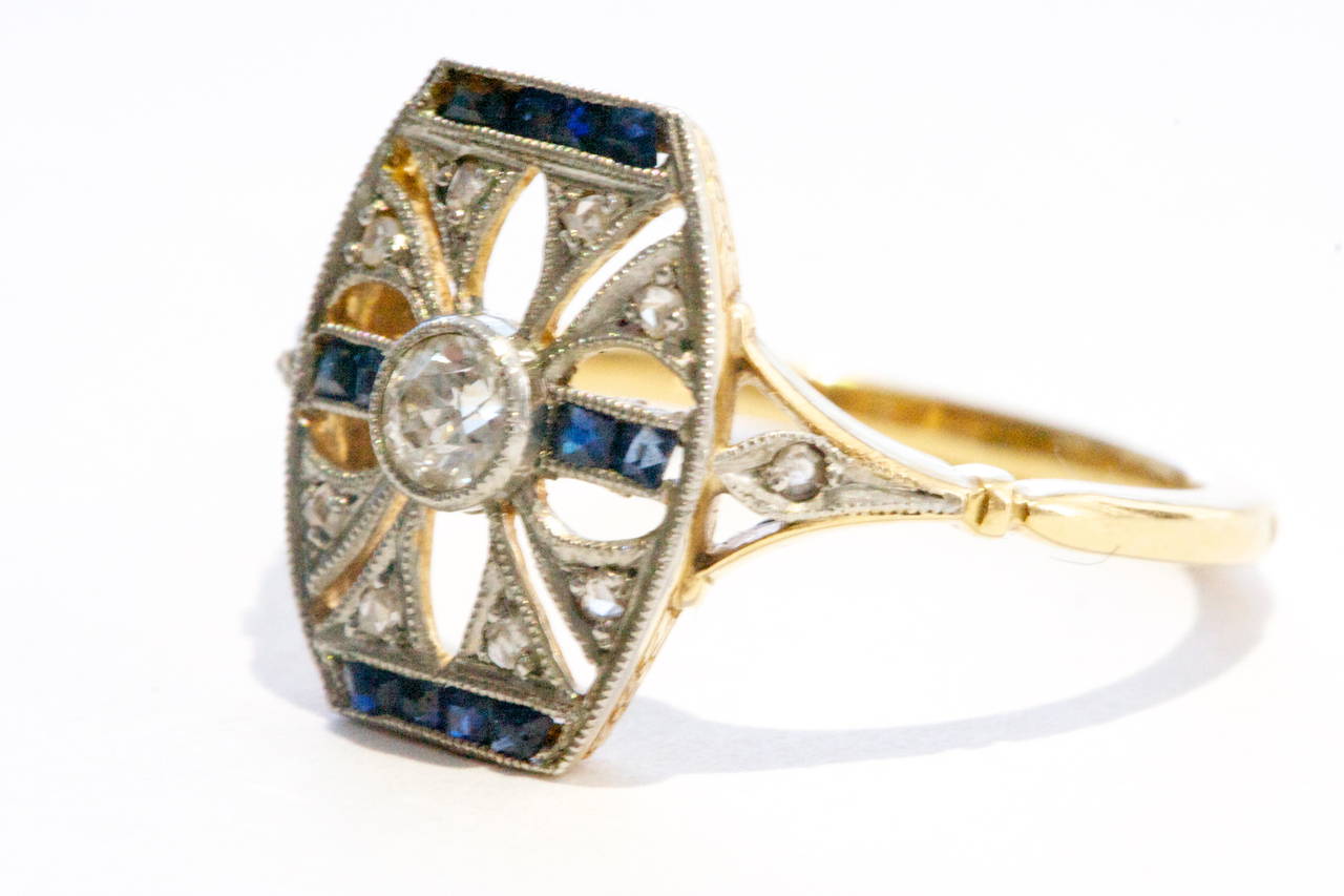 The ring has been designed with the historic fleur-de-lis. The symbol of the lily or lotus flower was first used by King Louis VI and was said to represent French royalty. The ring  uses old cut diamonds with square cut sapphires to liven the
