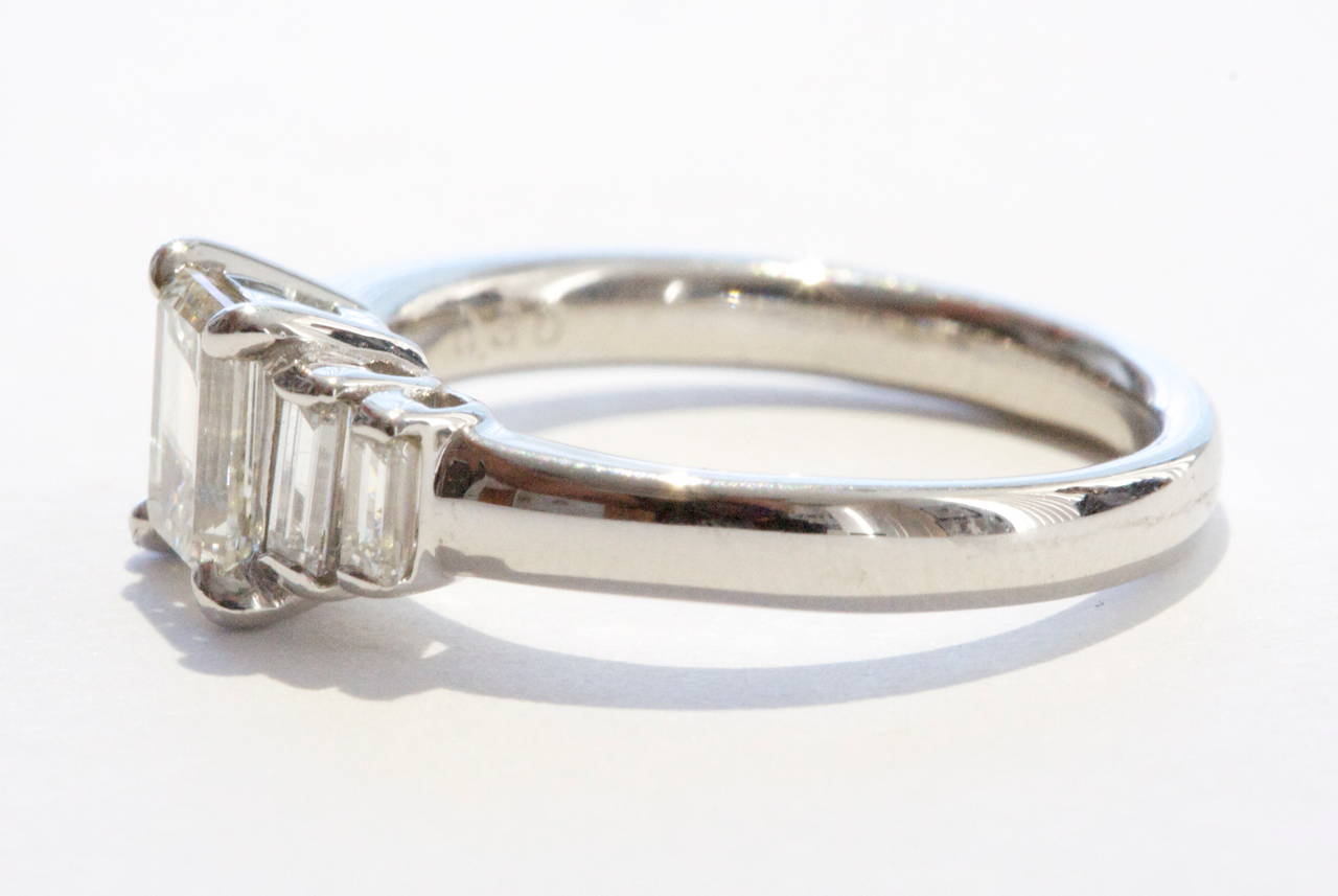 A subtle style has been used with this platinum ring to focus on the beauty of the center 0.74 carat emerald cut diamond. The main diamond is approximately I  color and VS clarity. It is accented by step cut baguette diamonds, also I color and VS