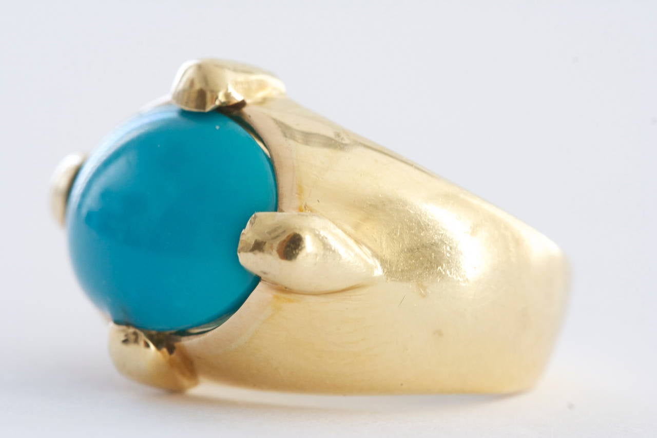 A beautiful electric blue color comes with this fine Persian turquoise. Designed in 18k gold with wide prongs adding to the picturesque face up.

Size 5 and can be re-sized.
