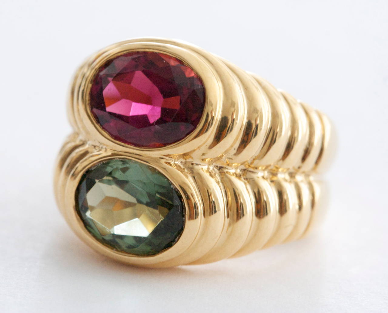 The classic two colored stone ring has become one of Bulgari's signature designs. With a nice balance of color created by rubelite and tourmaline stones bezel set in 18k layered yellow gold. Signed Bvlgari. 

Size 6 and can be re-sized.