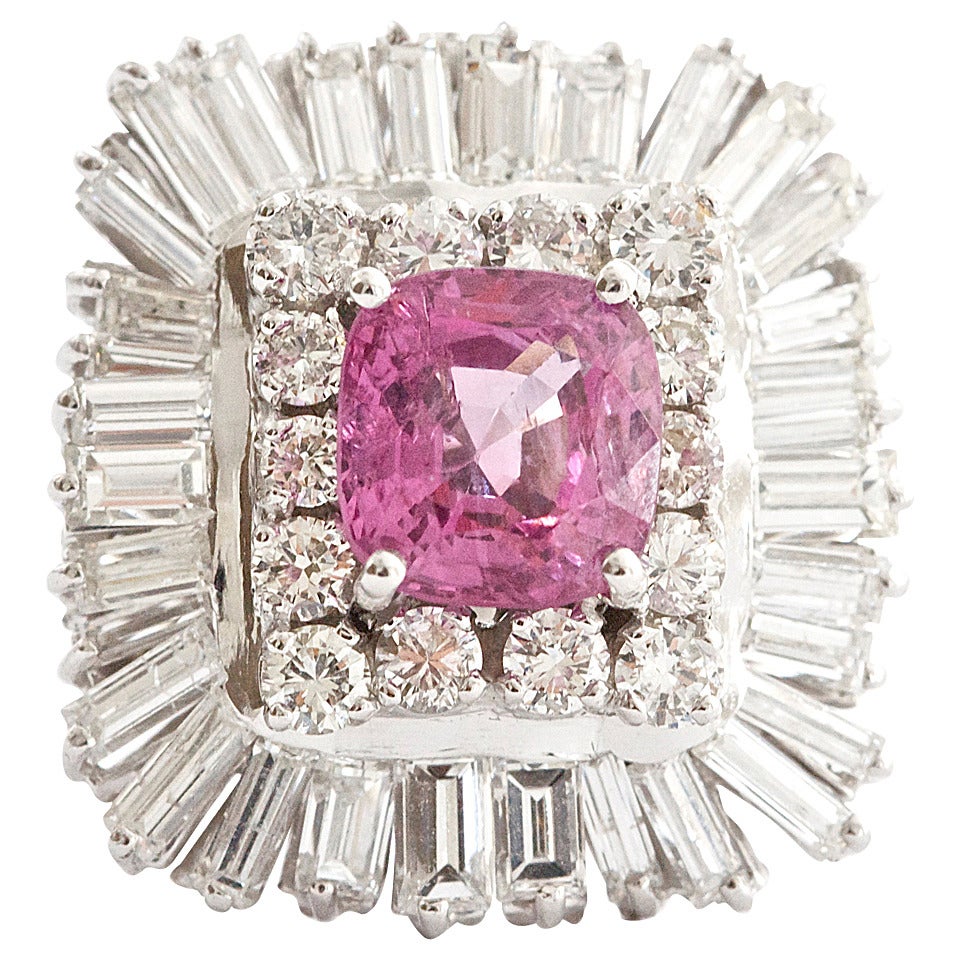 A stylistic ballerina ring highlighting  a 4.12 carat hot pink spinel that shows a true and lively color.  The spinel is surrounded by a nice balance of white color from the diamonds. The upper level of diamonds are round cuts and the lower level