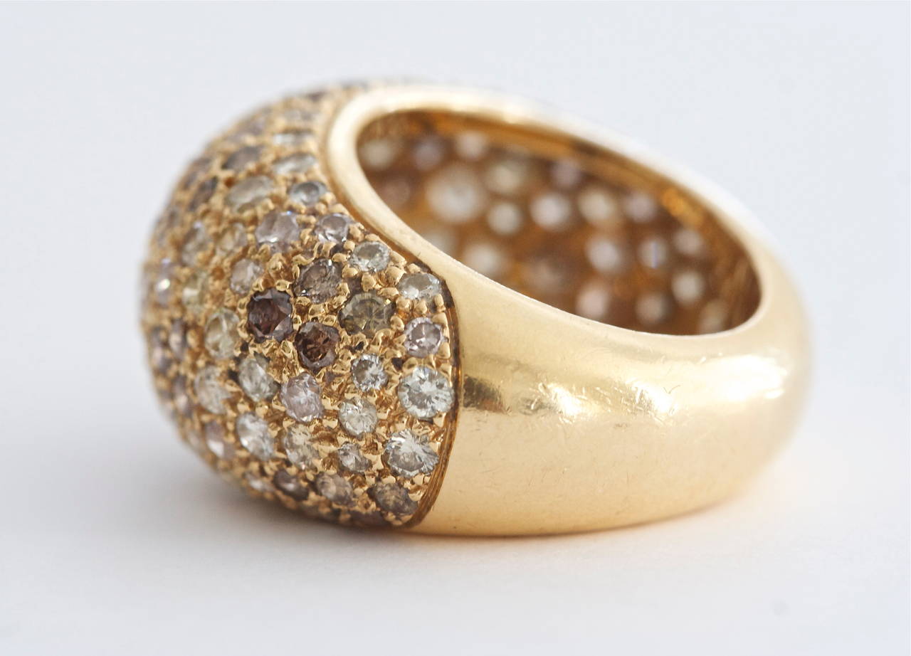 Cartier, elegant and timeless. The designer has effectively created a fascinating color display by combining colorless, champagne and yellow round cut diamonds all pave set in a domed fashion. Hand crafted in 18k yellow gold. Signed Cartier and