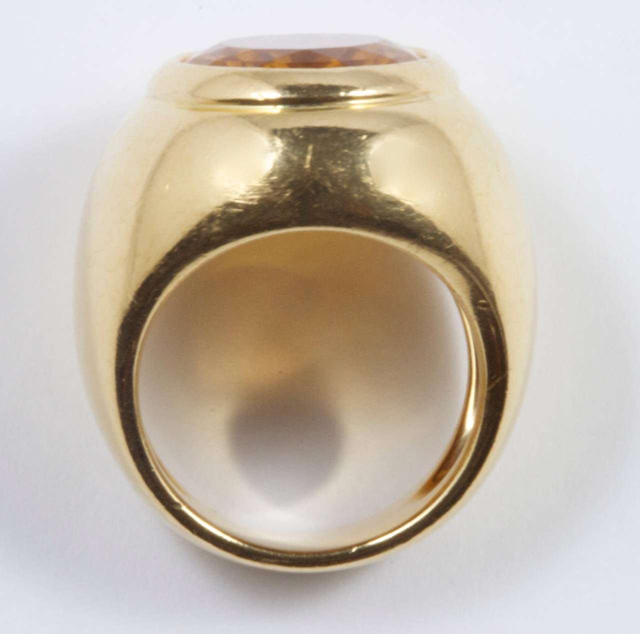 A big, sleek design from the jewelry house of Cartier. Fashioned with a lively orange citrine that easily transitions into the 18k yellow gold that embraces the gemstone. Signed Cartier, numbered and stamped 1997.

Ring size 51 or 5-3/4