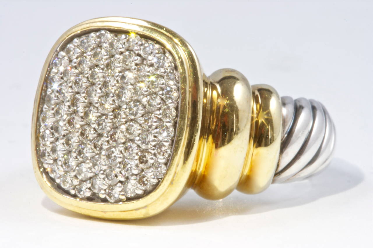 A big and bold design that is characteristic of David Yurman. This ring has been crafted with diamonds and a mixture of 18k yellow gold and stainless steel. Stamped DY and size 6.