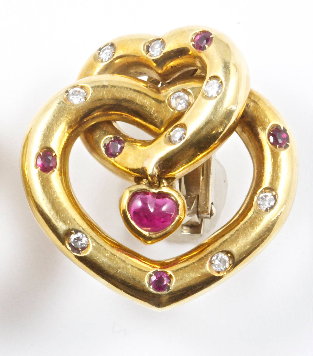 Intertwining hearts expressing love and bonding. In 18k gold with rubies and diamonds.