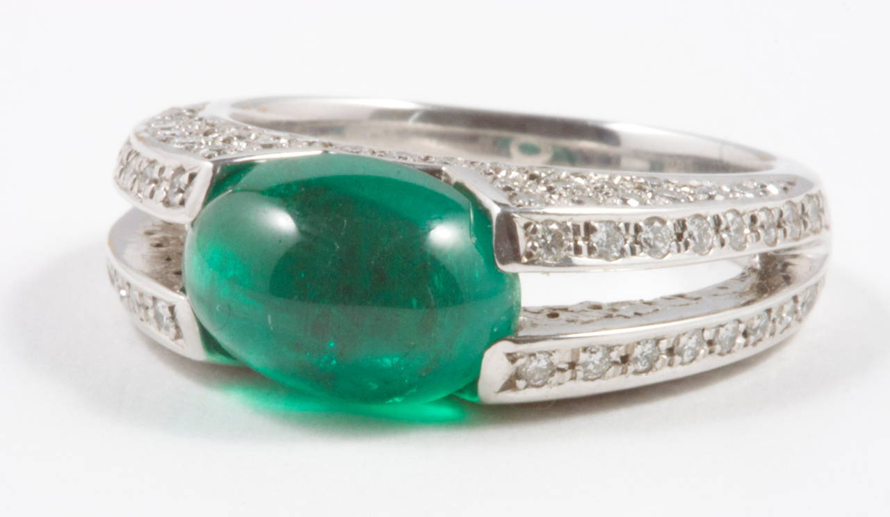 The bright green emerald is Colombian and weighs 3.35 carats. The beautiful emerald is held firmly in place by a well designed platinum ring. The diamond weight of 0.65 and the emerald weight is inscribed on the inner band of the ring. The platinum