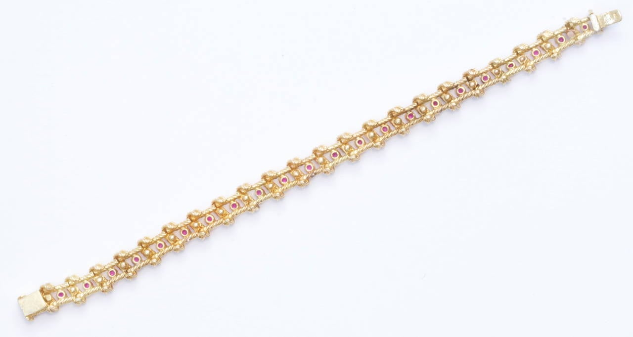 A beautifully made 1960's Tiffany straight line bracelet. Fashioned with 23 brilliant red rubies that have been expertly matched and separated by strips of fluted 18k yellow gold. Signed Tiffany. 7 3/4 inches.

Contact us if you are also