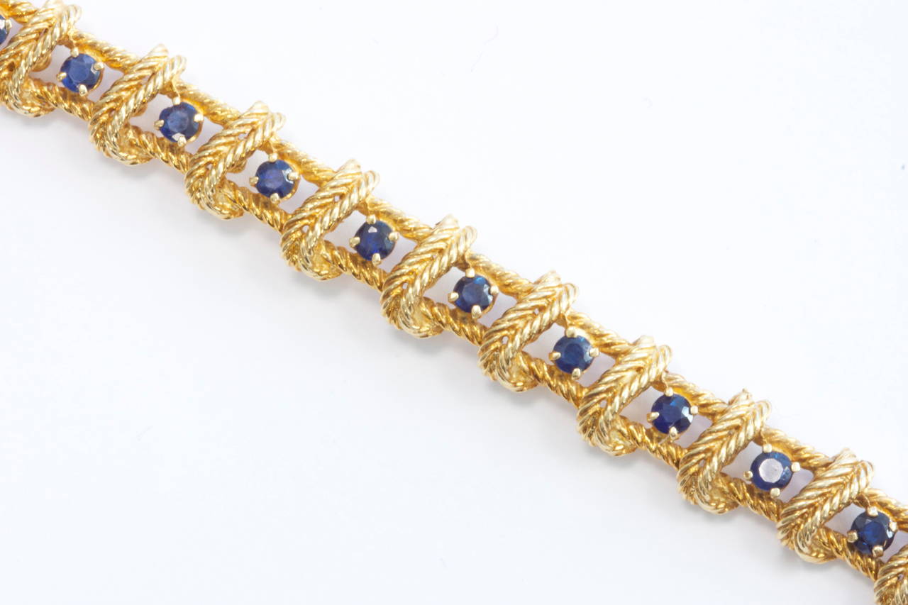 A beautifully made 1960's Tiffany straight line bracelet. Fashioned with 23 lively blue sapphires that have been expertly matched and separated by strips of fluted 18k yellow gold. Signed Tiffany. 7 3/4 inches.

Contact us if you are also