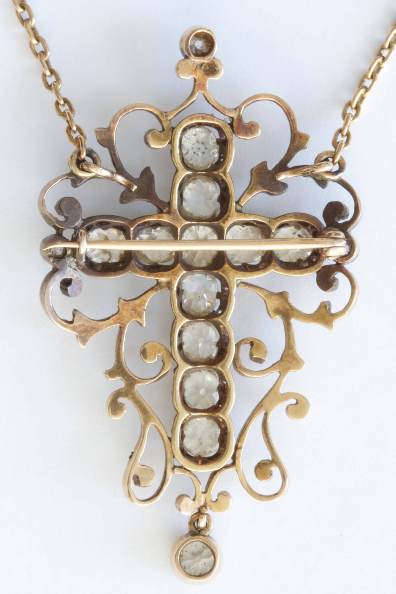 A beautiful antique diamond cross from the Victorian era. The cross has been designed with 12 old mine cuts diamonds weighing approximately 7.50 carats.  Elegantly hand crafted in gold and sterling silver. Also, may be worn as a brooch.