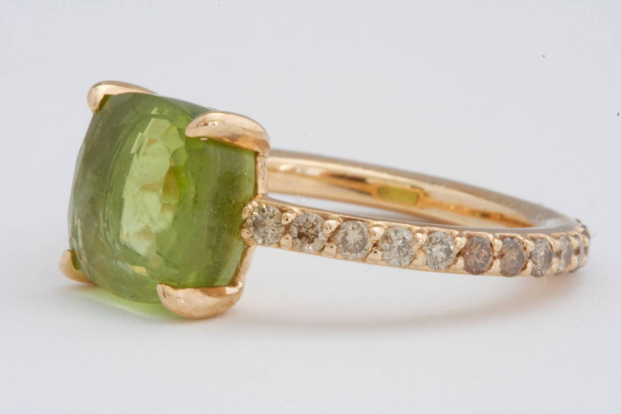 A clean and vibrant look from  Pomellato. Designed with cognac diamonds that go all the way around the band to feature a forest green faceted peridot. Crafted in 18k Gold and signed Pomellato.

Size 6-1/2

Please contact us if you are interested
