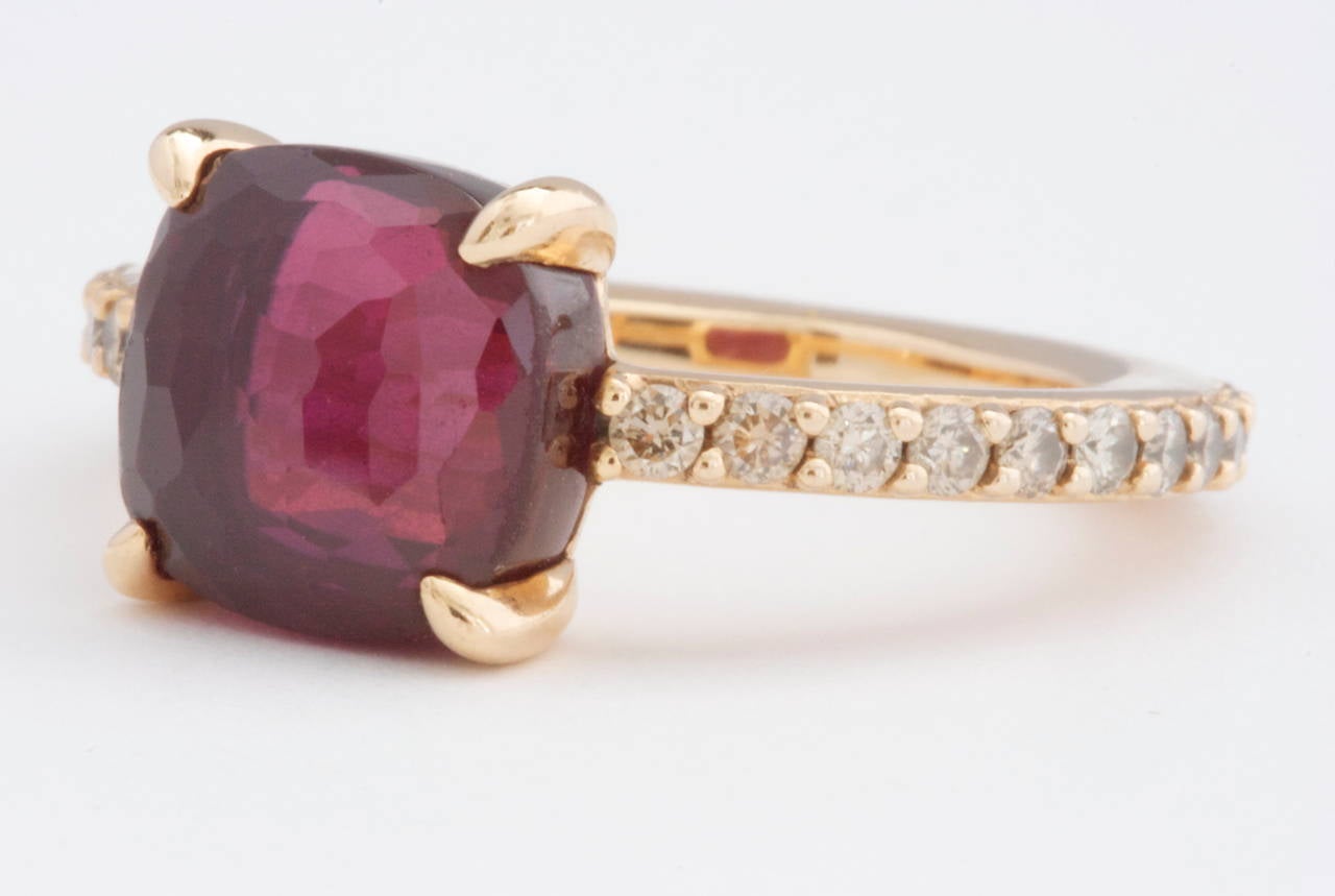 A clean and vibrant look from  Pomellato. Designed with cognac diamonds that go all the way around the band to feature a sparkling red faceted rhodolite garnet. Crafted in 18k Gold and signed Pomellato.

Size 6-3/4

Please contact us if you are