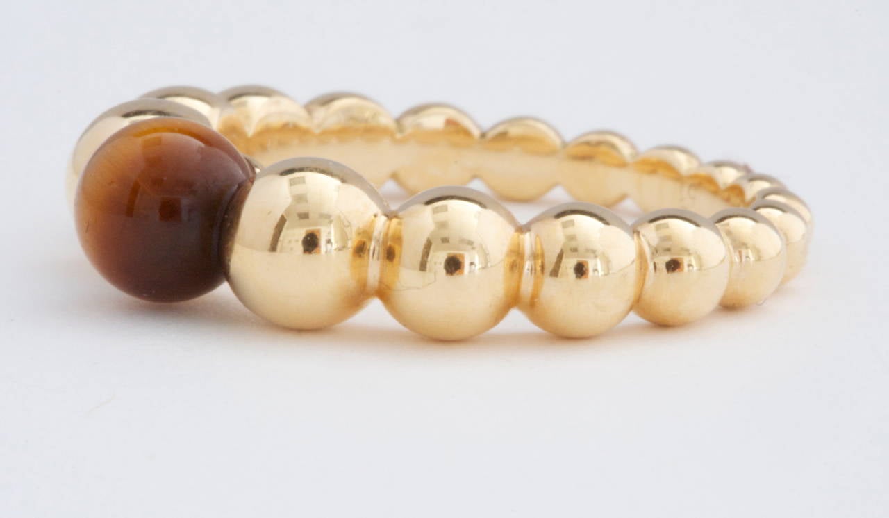 Van Cleef & Arpels, a long rich history of trend setting fashion that is still relevant today. Fashioned with a lovely multihued bead of tigers eye that is nicely complemented by descending beads of 18k yellow gold. Signed VCA and numbered.

Size