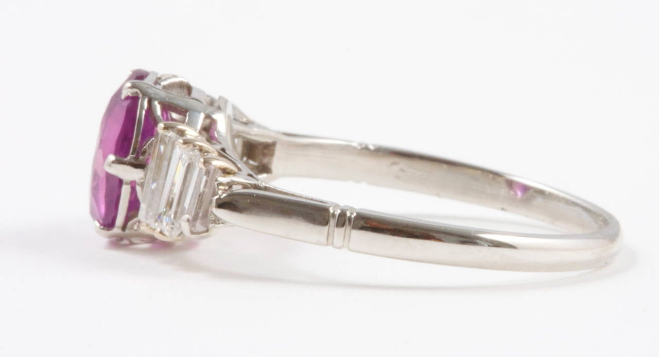 A colorful  pinkish-purple 1.49 carat sapphire has been accented with an avalanche of white, clean baguette cut diamonds. Hand crafted in a platinum ring.

Ring size 6 and can easily be re-sized.