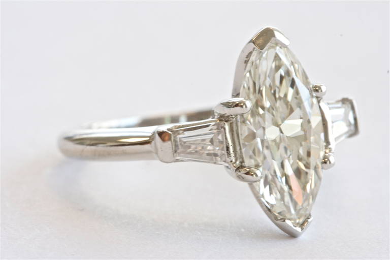 The marquise cut diamond weighs 1.62 carats and is H-I color and VS clarity. An excellent model of a  marquise cut. Set in a timeless platinum and diamond ring.