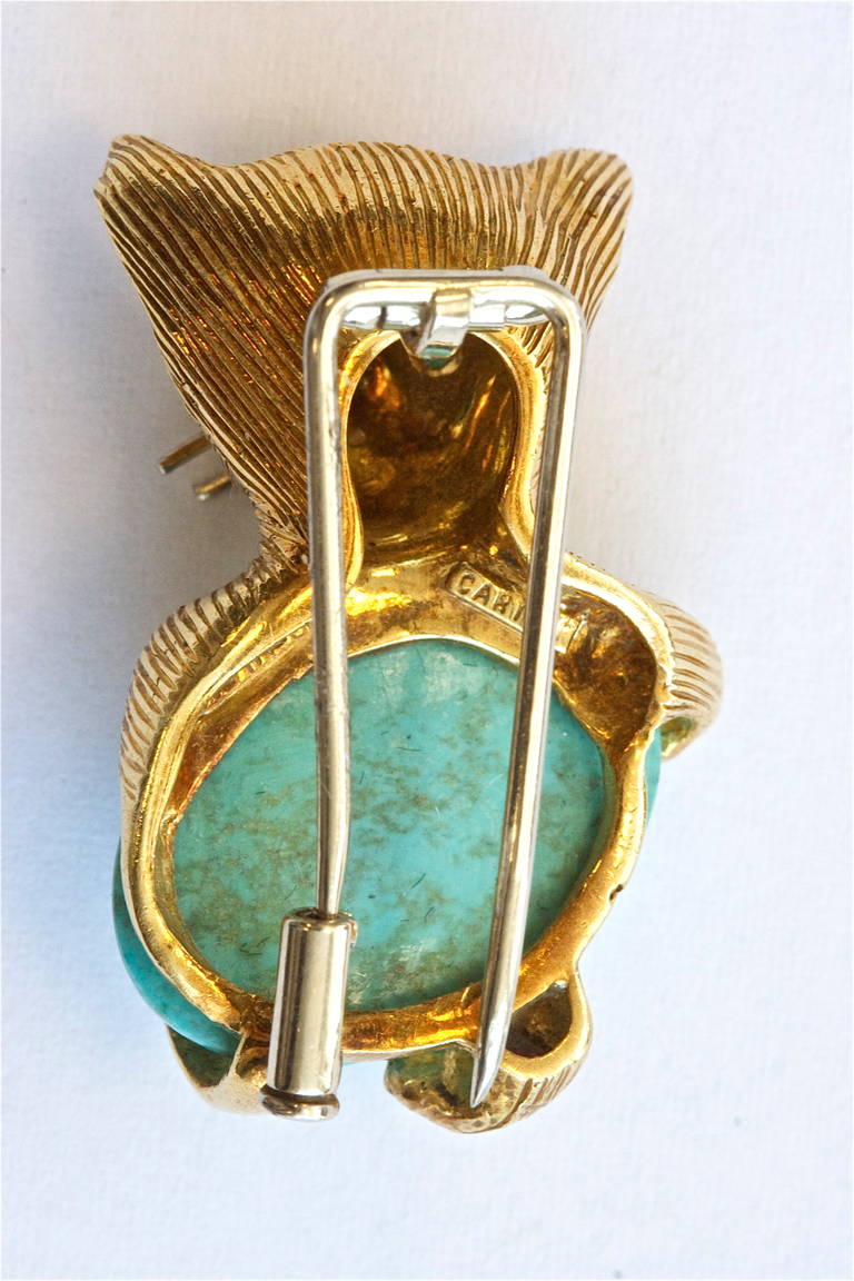 The Cartier cat. The cabochon turquoise and is nicely set in 
Italian 18k yellow gold with emeralds for eyes. Signed Cartier Italy.