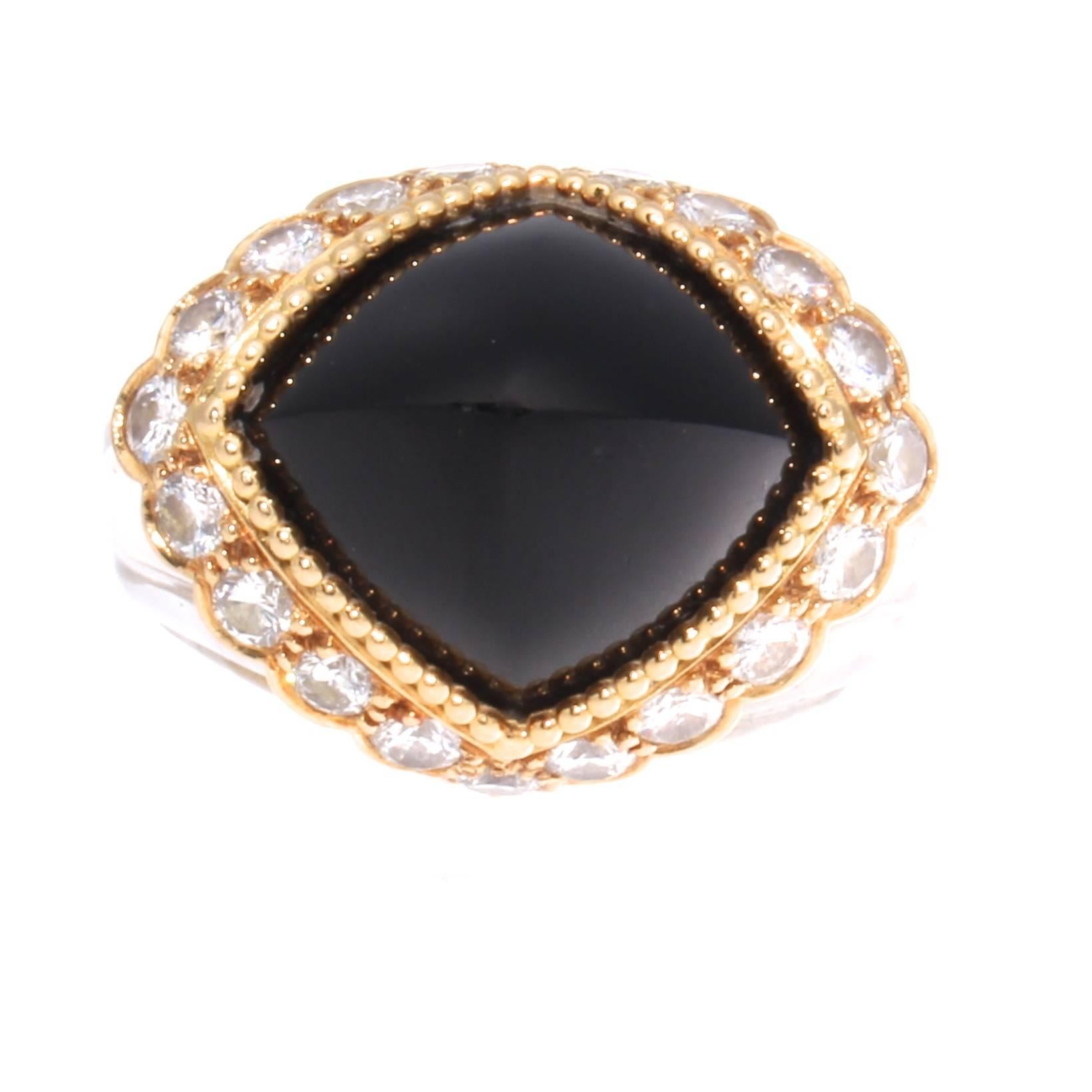 A big, bold eye pleasing creation with the classic use of yellow, black and white colors from the French jewelry house of Boucheron. Featuring a clean, sleek cabochon onyx that has been surrounded by a ring of clean, white round cut diamonds. The