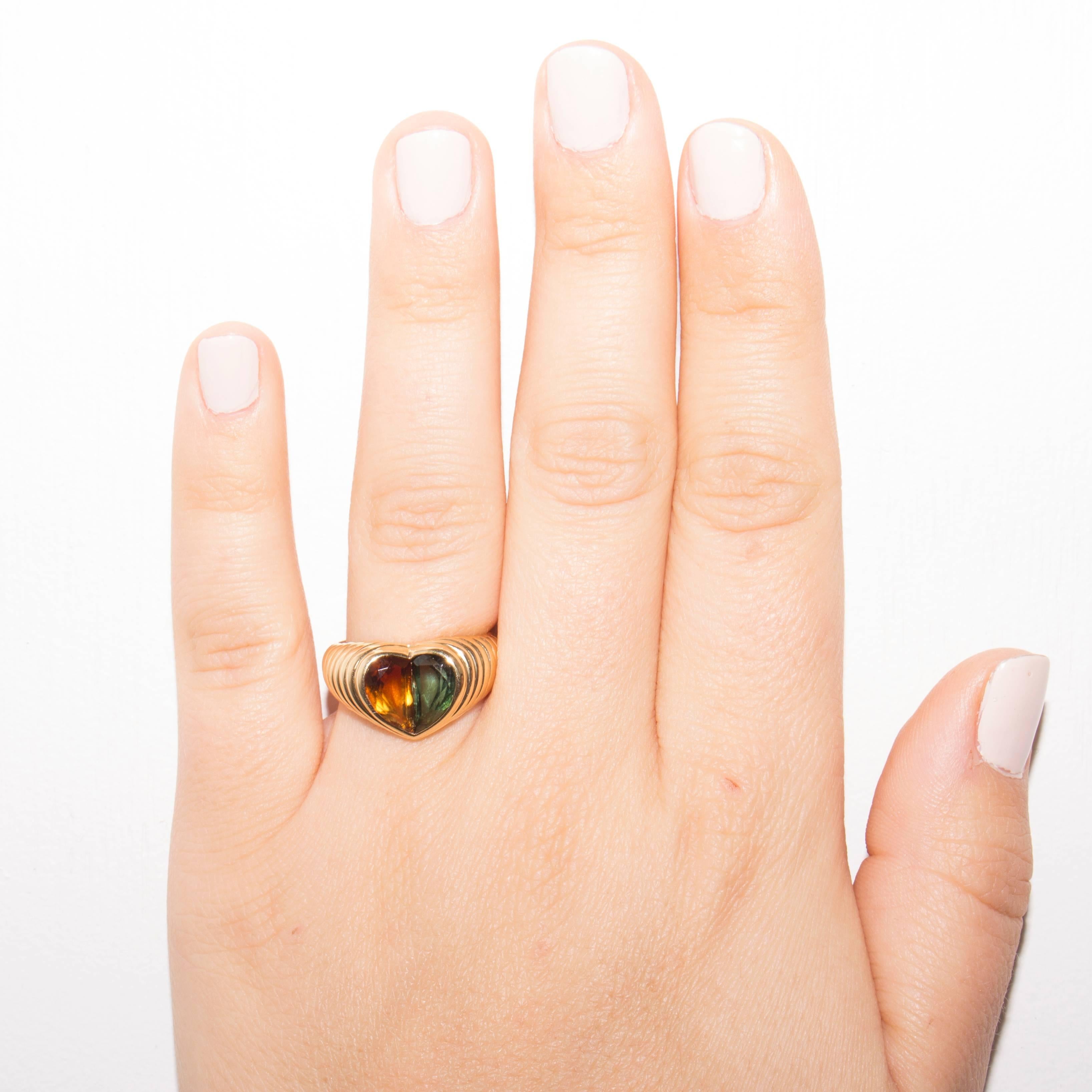 Stylish and colorful from Bulgari. Designed with a golden citrine and a green tourmaline set amid rolling contours of 18k gold. Signed Bvlgari. Ring size 6-1/2 and may be resized.

