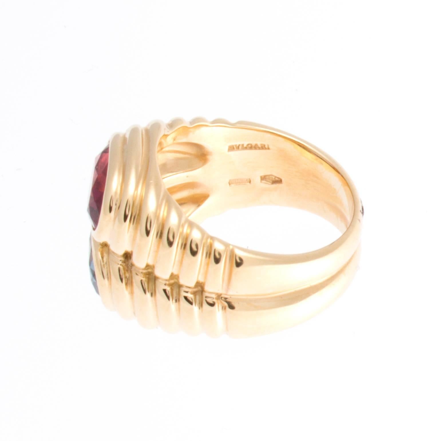 Stylish and colorful from Bulgari. Designed with a red rubelite and a blue topaz set amid rolling contours of 18k gold. Signed Bvlgari. Ring size 6 and may be resized.
