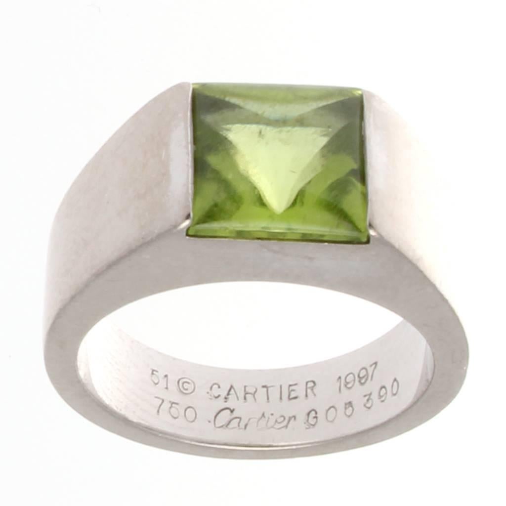 Cartier, elegant and timeless. Fashioned with a square cut cabochon green peridot. Crafted in 18k white gold. Signed Cartier.

Ring size 5-3/4 and may be resized. 
