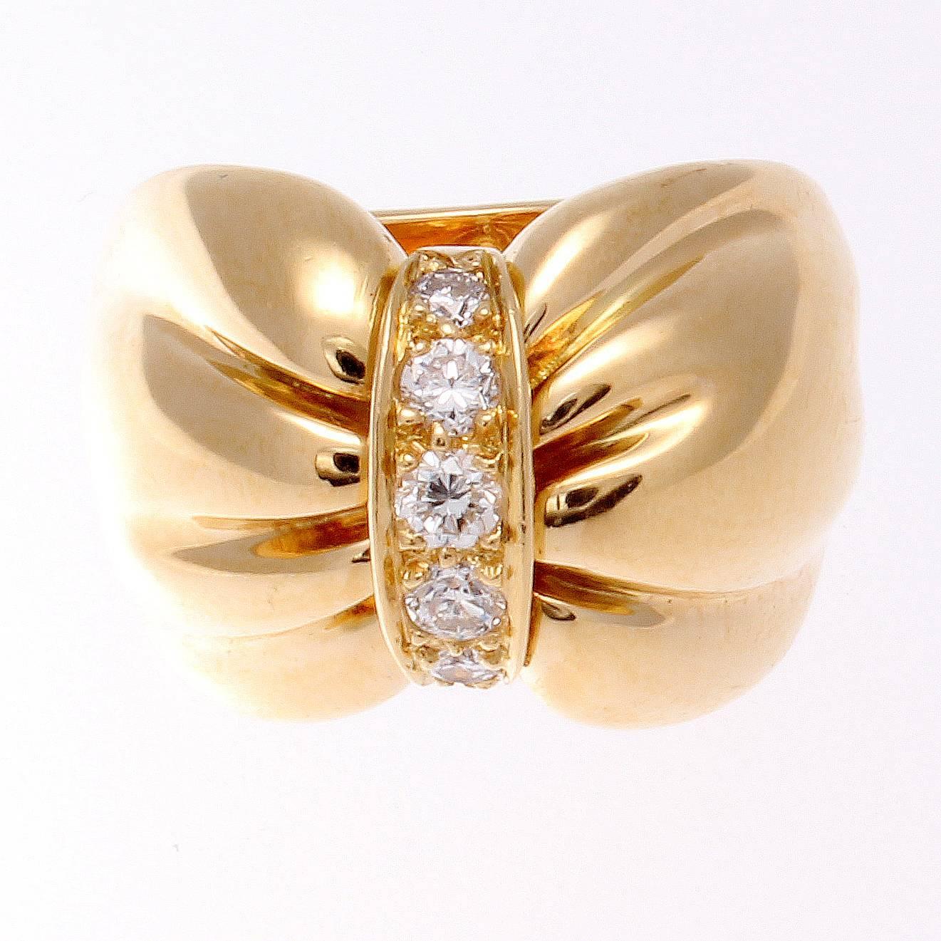 Van Cleef & Arpels, a long rich history of trend setting fashion that is still relevant today. The classic bow motif that has been fashioned with near colorless diamonds and crafted in 18k yellow gold. Signed VCA and numbered.

Ring size 5-1/4 and