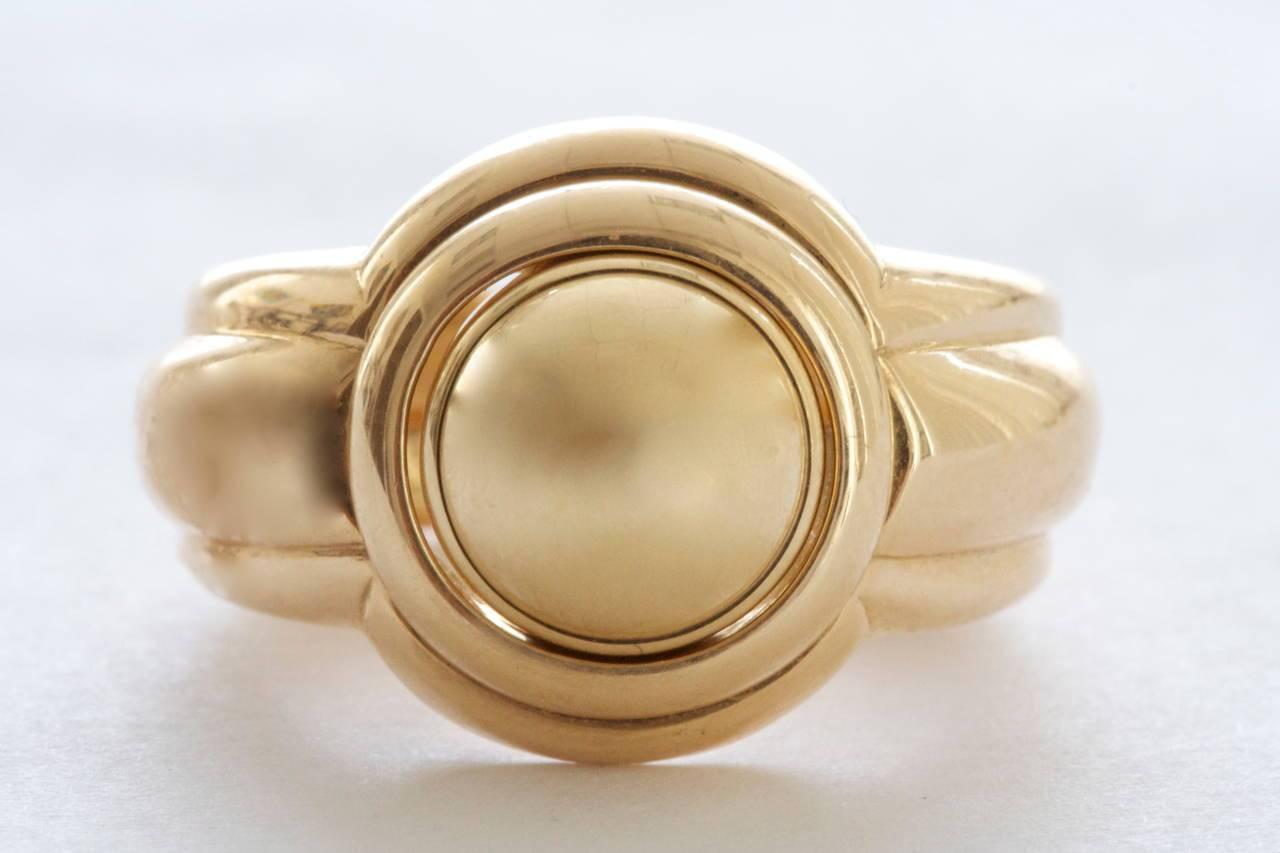 A creative and practical design from the French jewelry house Piaget. Crafted in 18k yellow gold the ring has an interchangeable tourmaline and gold center dome. Size 56.

Signed Piaget and dated 1993.