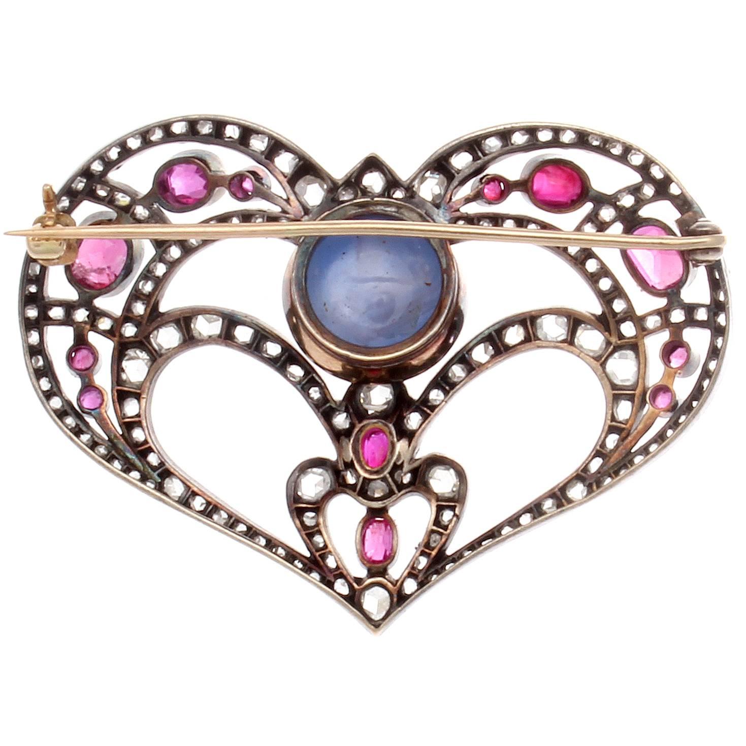 An endearing heart fulfilled with life and color. Featuring a beautiful star sapphire that has flowing veins of diamonds and spinel gently creating this heart motif. Hand crafted in silver and 18k gold.