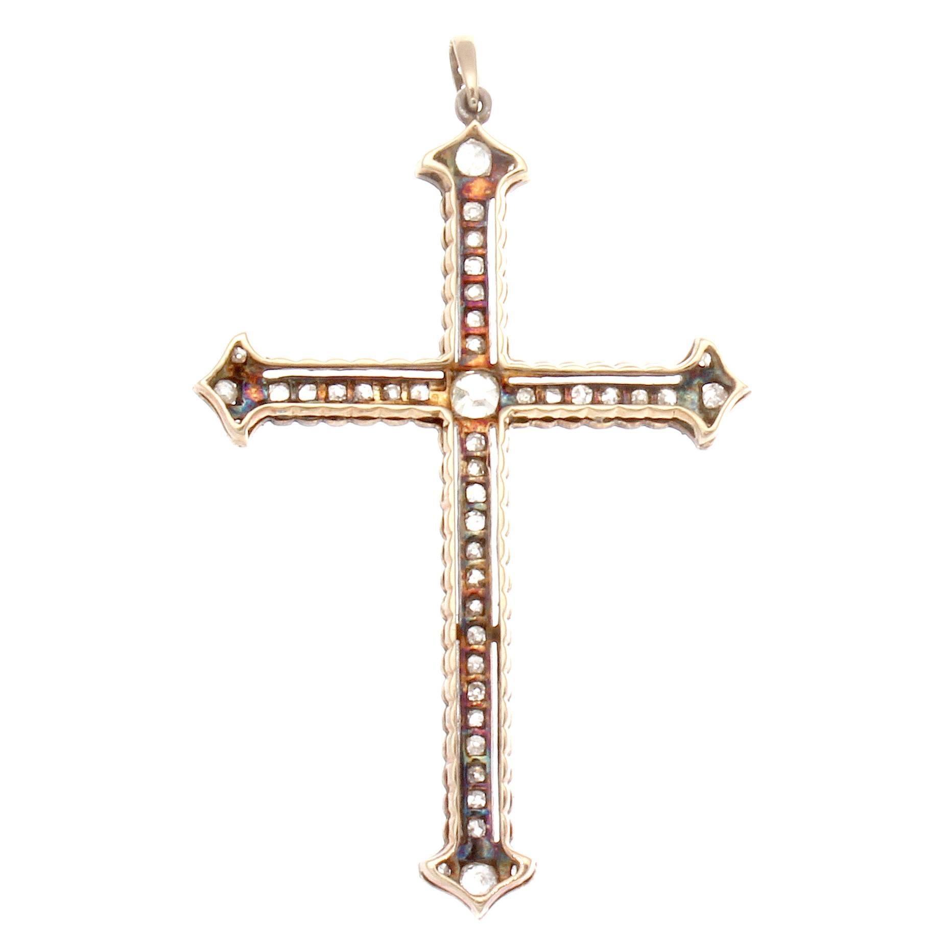 An iconic representation of the holy cross. Commonly done during the Victorian era this specific replication has been designed with 46 old cut diamond. 
The center diamond is approximately 0.50 carats. Hand crafted in gold and silver.