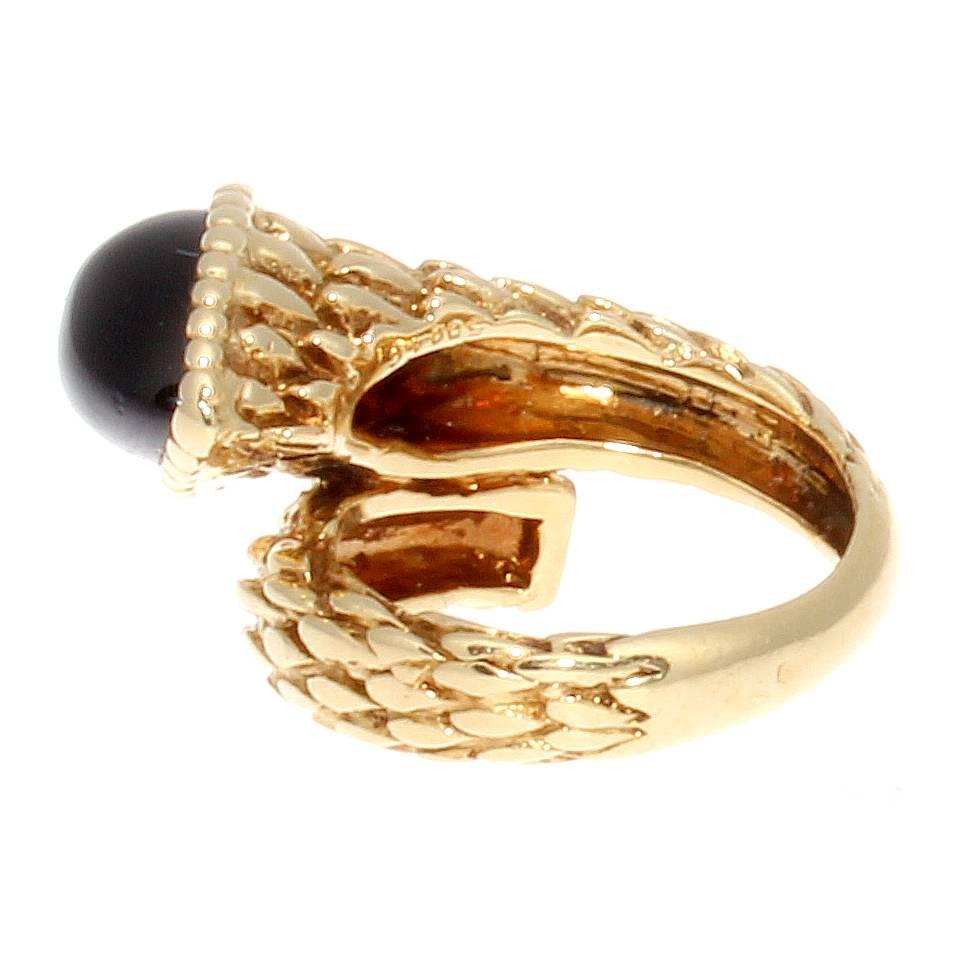 The extremely desirable snake ring from the French jewelry house, Boucheron. Featuring the striking color combination of jet black onyx and gleaming 18k yellow gold. The snake motif has been created by a head of cabochon cut onyx and the skin is