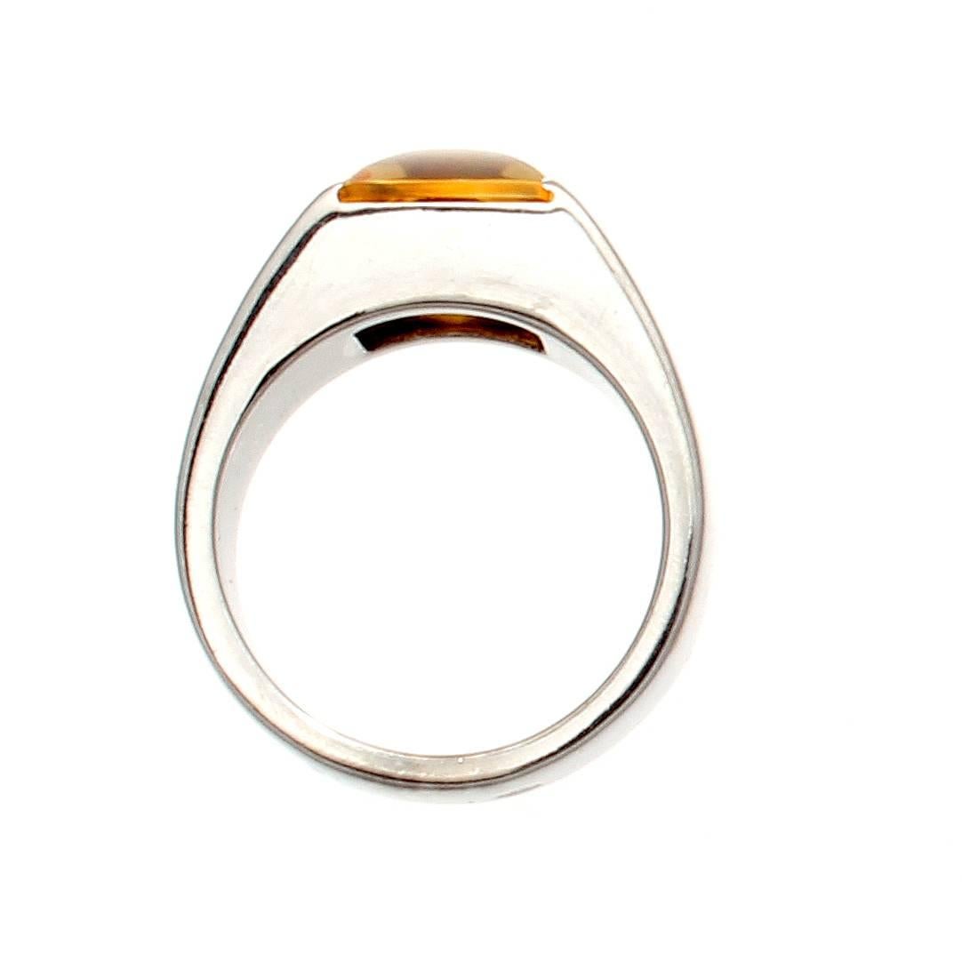 The sleek and modern Tank ring from Cartier. Featuring a single cabochon golden citrine that has been complimented by smooth lines of 18k white gold. Signed Cartier and numbered.

Ring size 5 1/4 and may be re-sized.