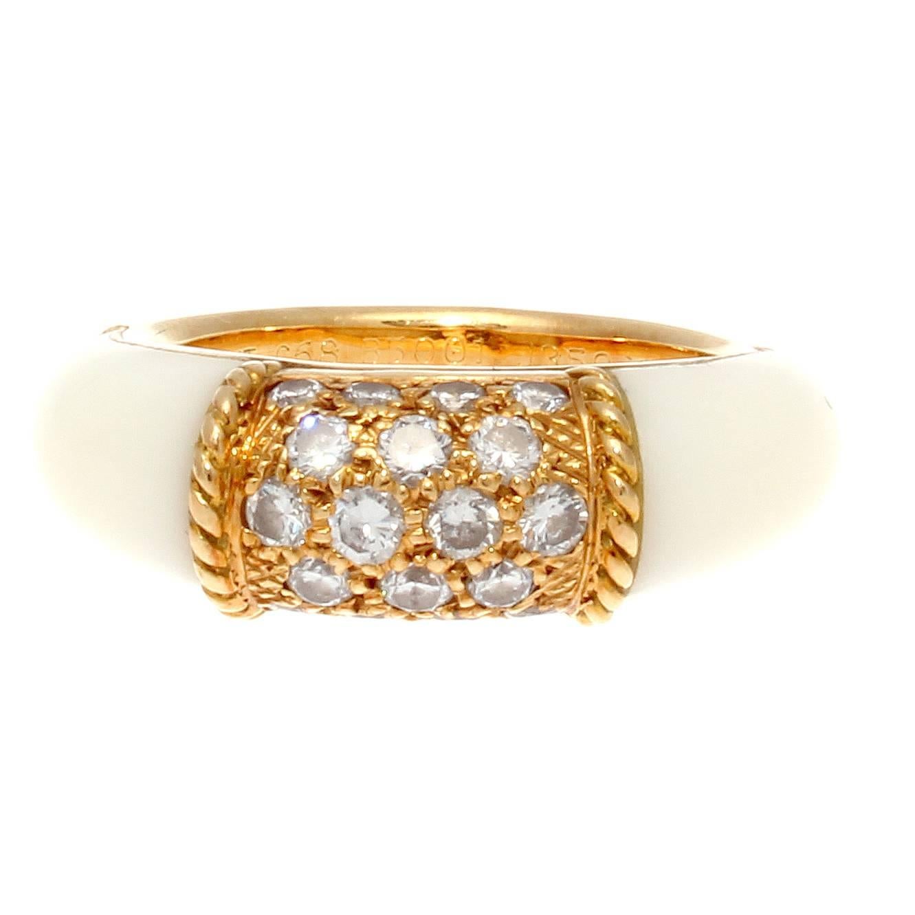 The lovely and popular Van Cleef & Arpels Philippine ring. Stylized with textured gold that is embedded with clean, white diamonds throughout. The garden of diamonds has been enclosed by gold rope motifs that have white coral cascading down either