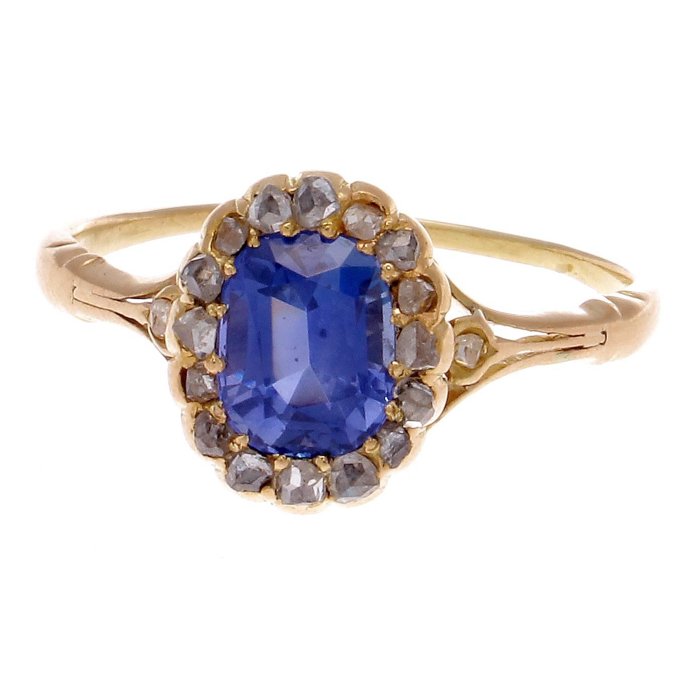 A strikingly colorful antique halo engagement ring that has withstood time, still being one of the most popular designs today. Featuring a vibrant royal blue sapphire that has been lassoed in by a ring of white, clean diamonds. GIA certified as