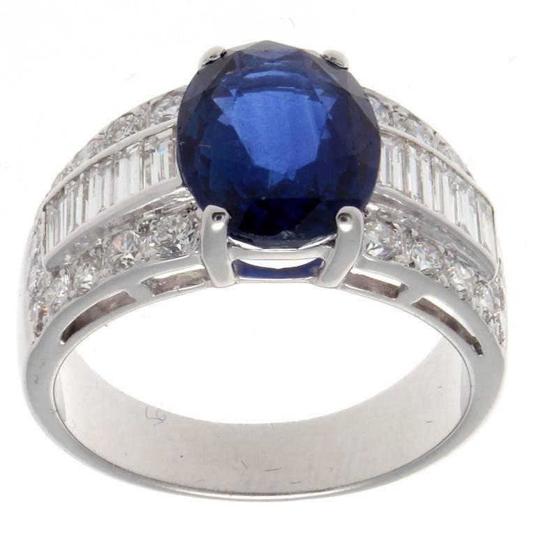 A luster of color bound to catch any eye. The deep vivid blue exudes from the oval cut 4.50 carat lively sapphire. Accented with a barrage of near colorless baguette and round cut diamonds. Crafted in 18k white gold and stamped with French