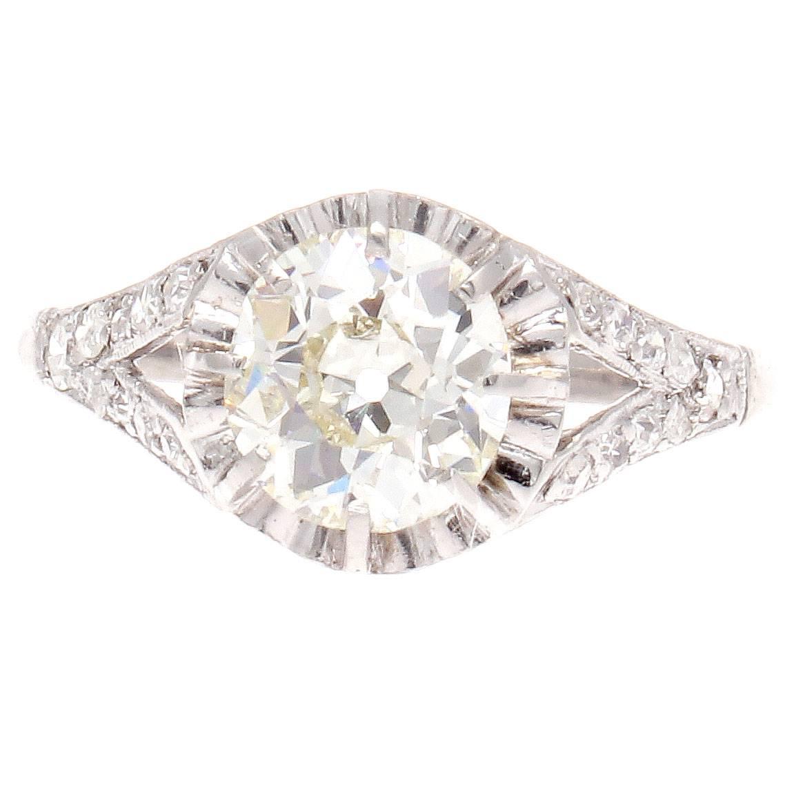 An alluring creation of true elegance capturing the art deco time/period. The center 1.18 carat diamond has been GIA certified as M color and VS1 clarity. The designer has creatively surrounded the diamond with vibrant platinum reflecting the light