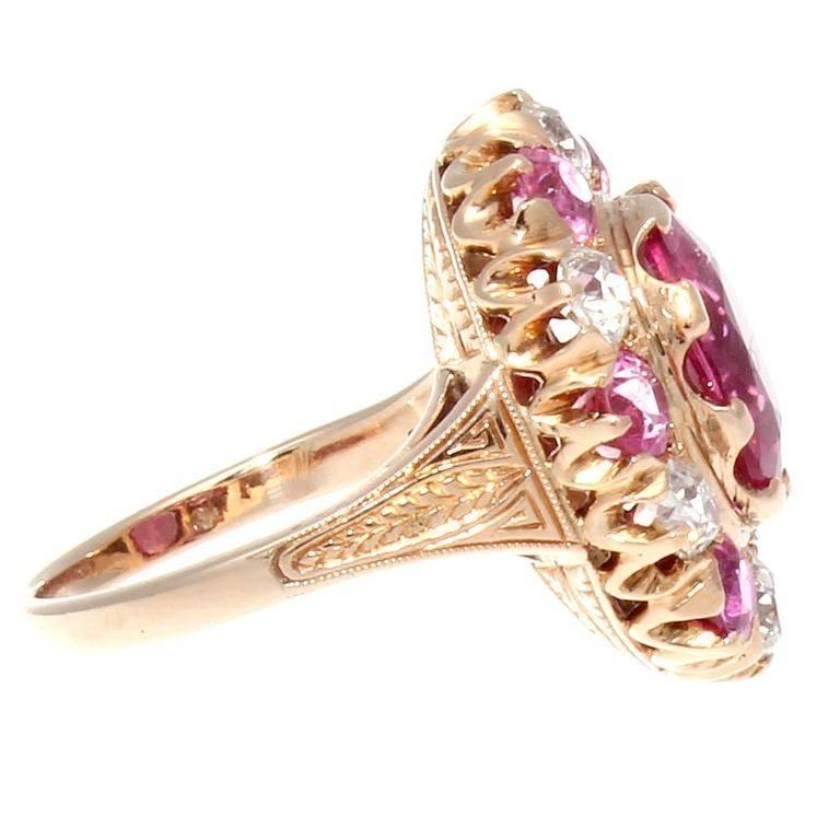 A lovely color combination featuring vivid pinks and bright whites. The featured bright pink rubellite center has been surrounded by a supporting cast of pink sapphires and white, clean diamonds in the classic halo style. Hand crafted in an 18k rose