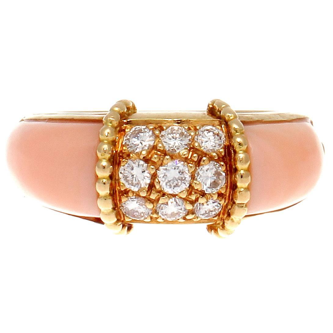 A well designed ring using angel skin coral, diamonds and textured gold. Featuring 9 colorless diamonds weighing approximately 0.45 carats, embedded in textured 18k gold. Accented by lustrous angel skin coral that cascades down either side of the