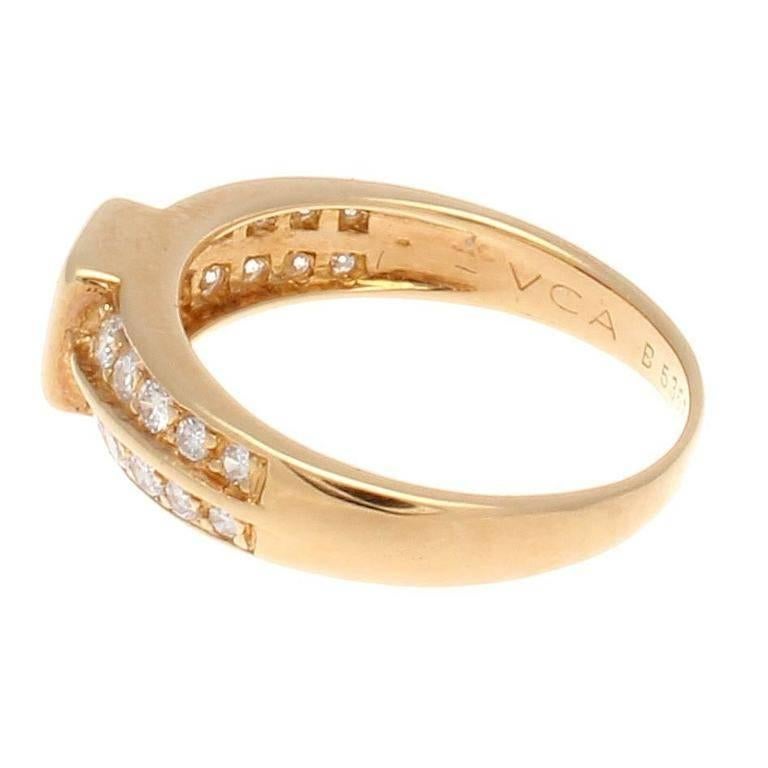 An effortless refinement of color and style from Van Cleef & Arpels. Designed with a vivid red square cut ruby is bezel set and accented by 2 rows of descending near colorless diamonds on either side. Crafted in 18k yellow gold. Signed VCA and
