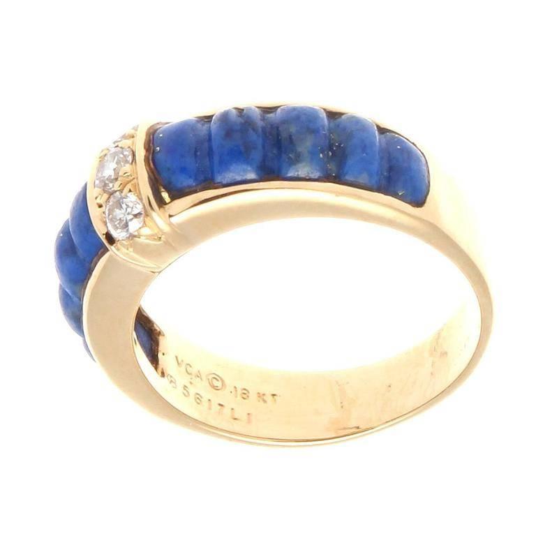 Van Cleef & Arpels, a long rich history of trend setting fashion that is still relevant today. This ring has been fashioned with glowing multi hued blue lapis lazuli that is complemented nicely by 3 near colorless diamonds. Crafted in 18k yellow