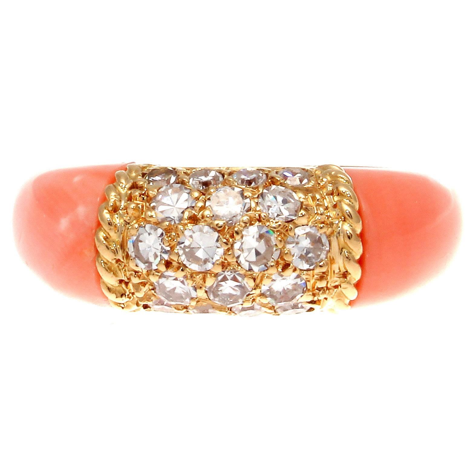 The classic Philippine ring from Van Cleef & Arpels. Designed with pave set diamonds in textured 18k yellow gold accented by glowing angel skin coral cascading down either side. Signed VCA, numbered and stamped with French hallmarks.

Ring size 4