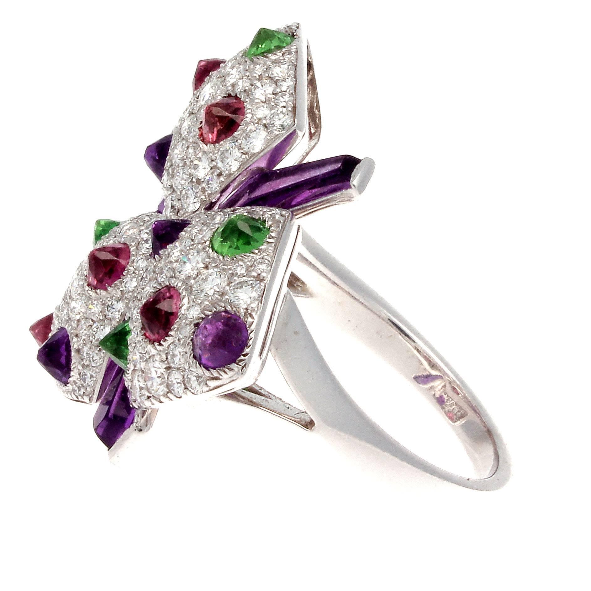 A blossoming flower of color from the orchid collection masterminded by Cartier. Featuring pedals with white, clean diamonds interspersed with color from the bright translucent cabochon green garnet, red rubelite and purple amethyst. Further
