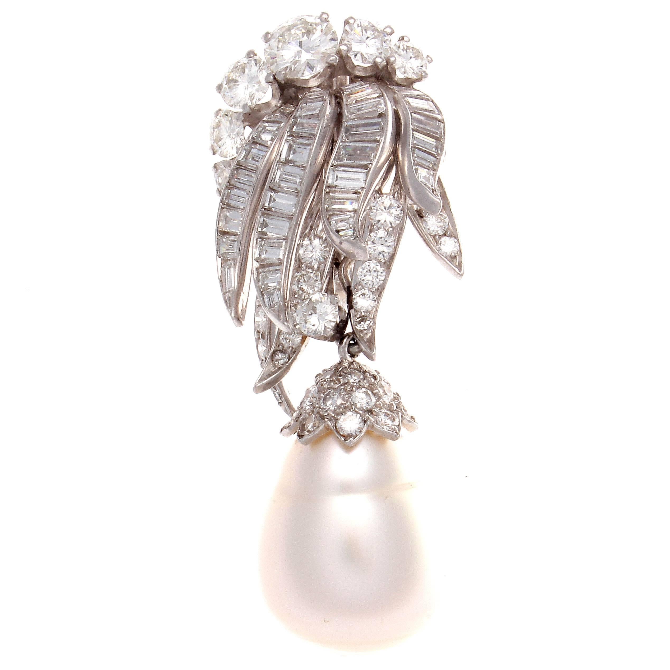 A serene example of grace and luxury from David Webb. Featured In the classic day and night design with approximately 12 carats of round and baguette cut diamonds which are E-F in color VS+ in clarity. Accompanied with large pearl drops that can be