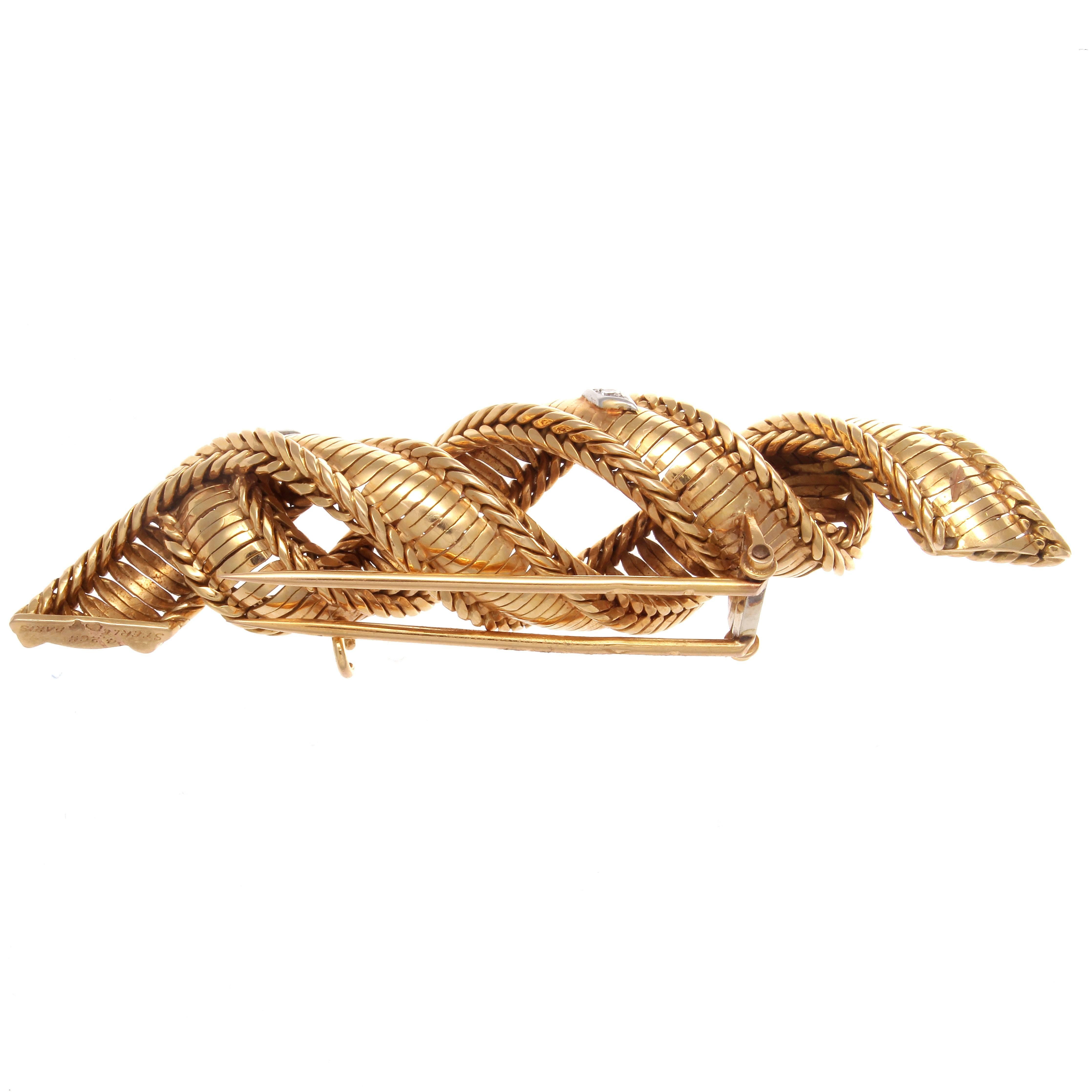 A continuum of excellence and style from Sterle Paris. The brooch is made of swirls of ribbon like braided gold containing 4 symmetrically placed white diamonds. Signed Sterle Paris with French hallmarks. In 18k gold.

3 inches long and 5/8 inches