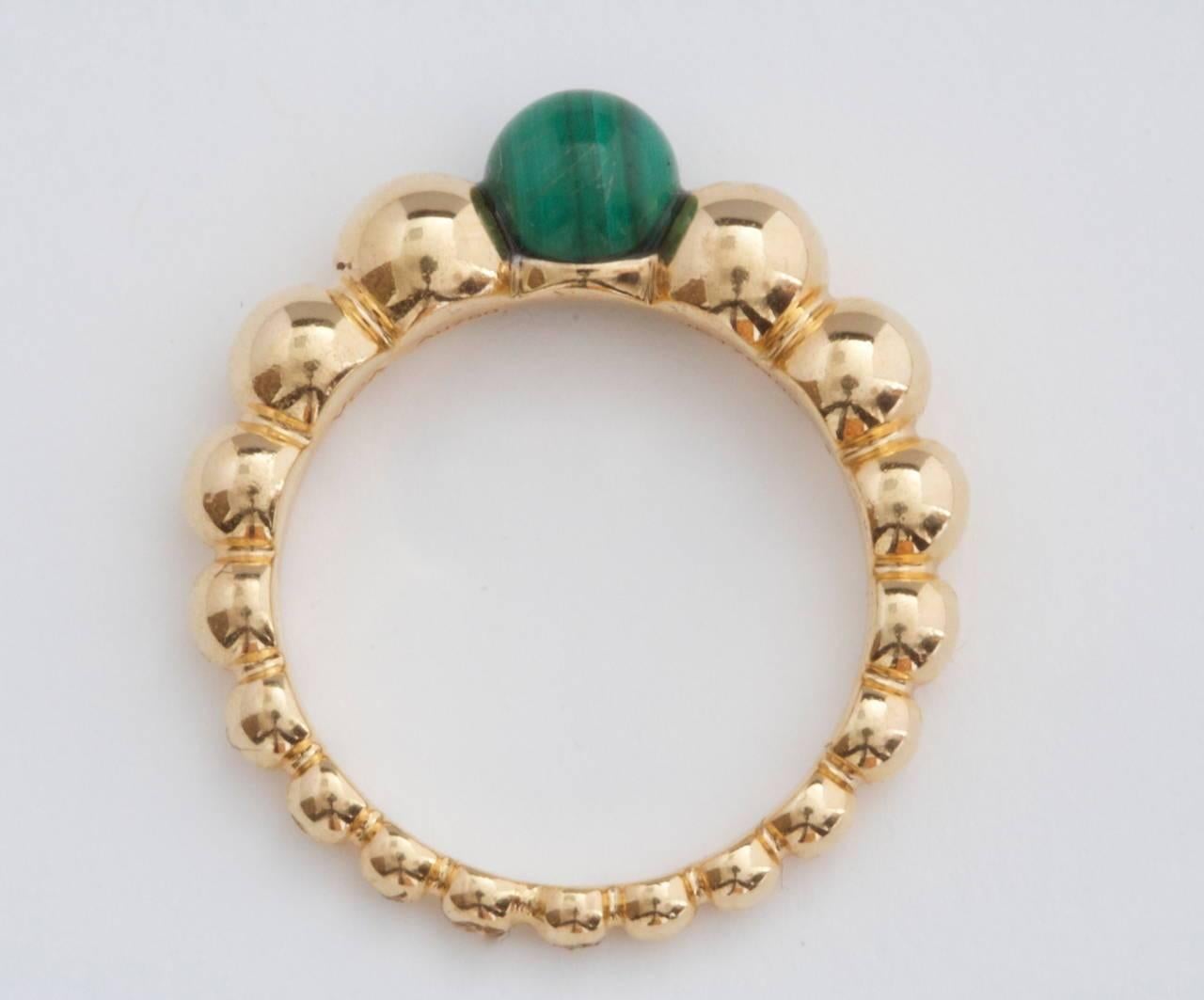 Van Cleef & Arpels, a long rich history of trend setting fashion that is still relevant today. Fashioned with a lovely multi hued green bead of malachite that is nicely complemented by descending beads of 18k yellow gold. Signed VCA and numbered. 