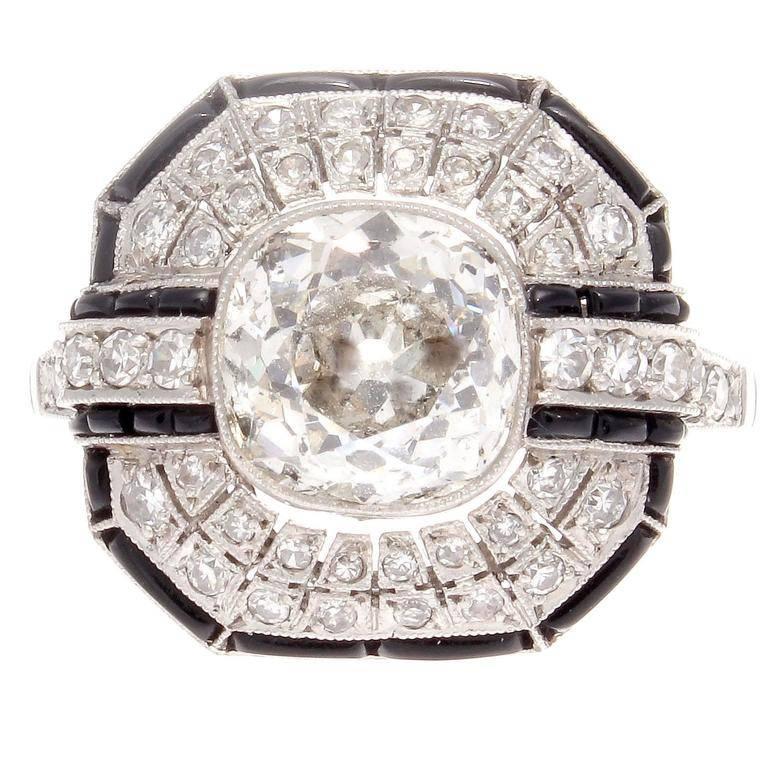A creation of true excellence inspired by the historic Art Deco period. Featuring an approximately 2.50 carat imperfect old cushion cut diamond that is H-I in color. Accented by a dome of symmetry that is designed with perfectly matching diamonds