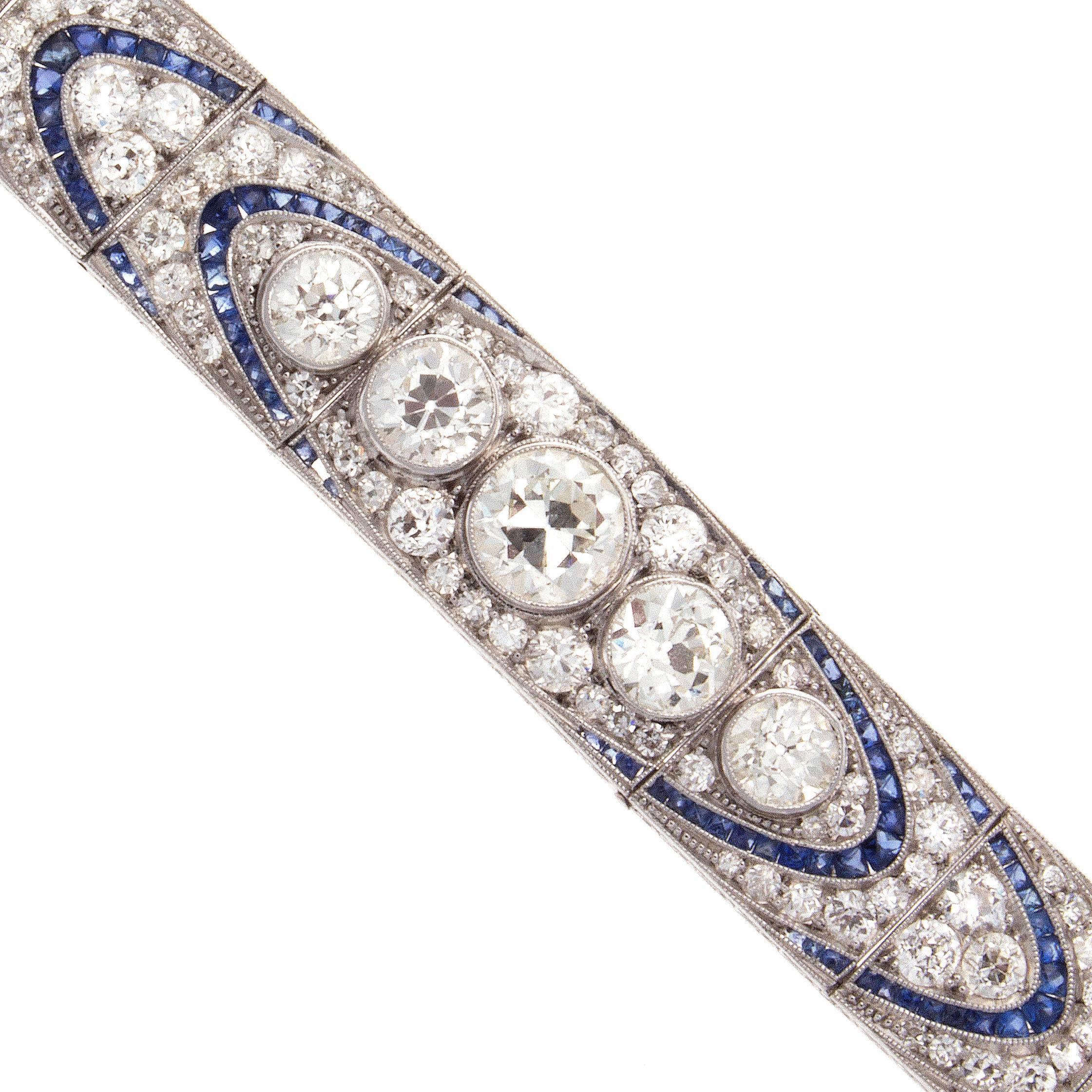 An  art deco classic using combinations of color to create this alluring bracelet. Designed with links of numerous perfectly matching white, clean diamonds and vibrant blue sapphires. Featuring 5 main old European cut diamonds that descend in size