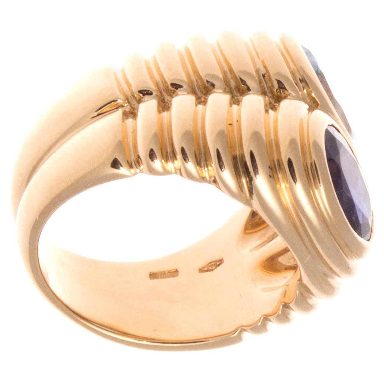 Stylish and colorful from Bulgari. Designed with a lively ocean blue topaz and a vibrant purple amethyst set amid contours of 18k gold. Signed Bvlgari. 

Ring size 5-1/2 and may be resized to fit.