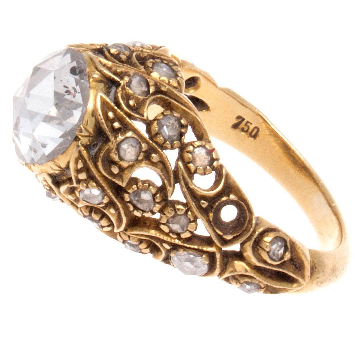 An elegant antique design from the early victorian era. Featuring an approximately 1.70 carat rose cut diamond that is elevated by intricately hand crafted 18k gold, with numerous matching rose cut diamonds. 

Ring size 6-3/4 and may be resized.