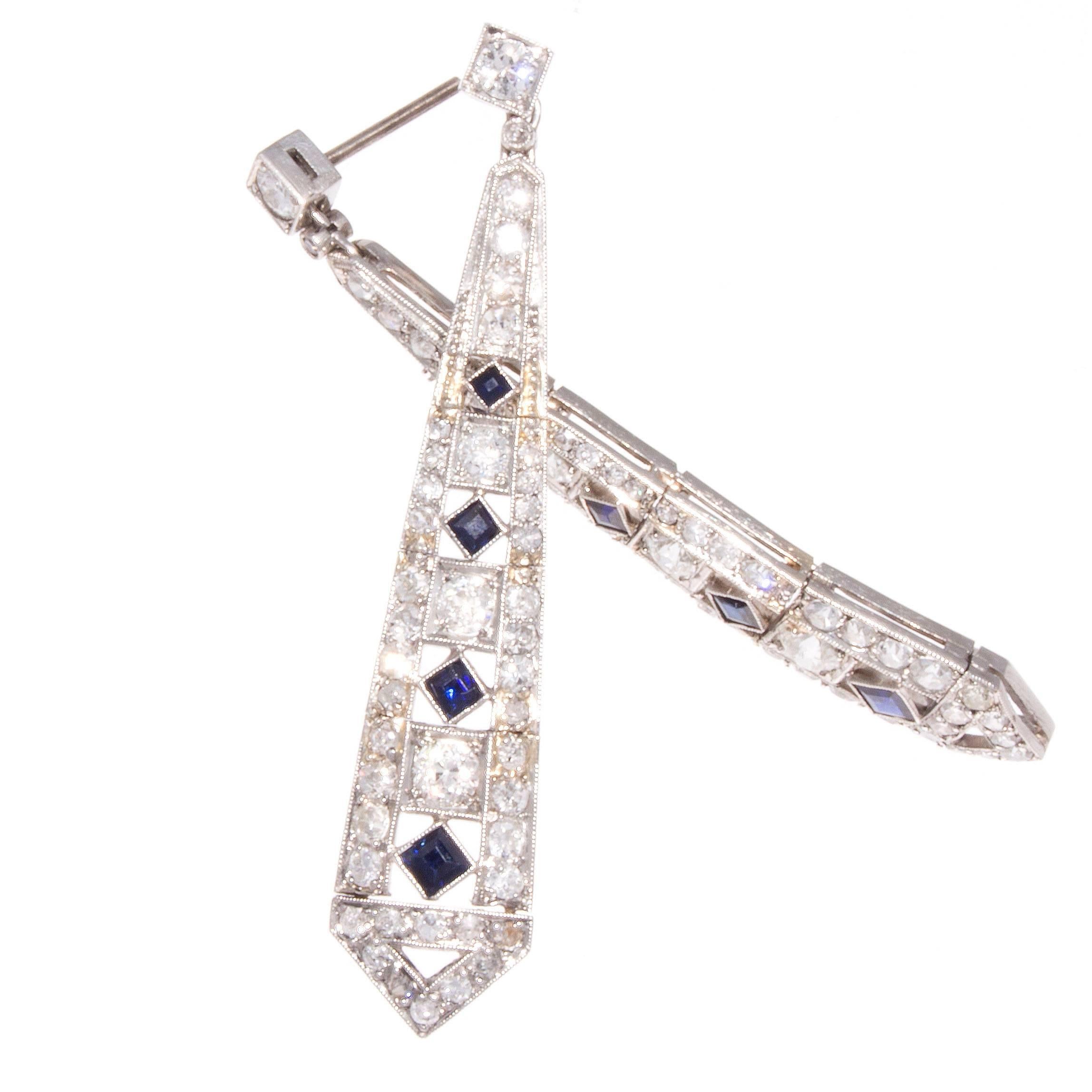 An outstanding creation true to the art deco period. Designed in a classic geometric architectural style. With white, clean diamonds cascading down the hand crafted platinum earrings and strategically placed vibrant blue sapphires. 

2 inches long.
